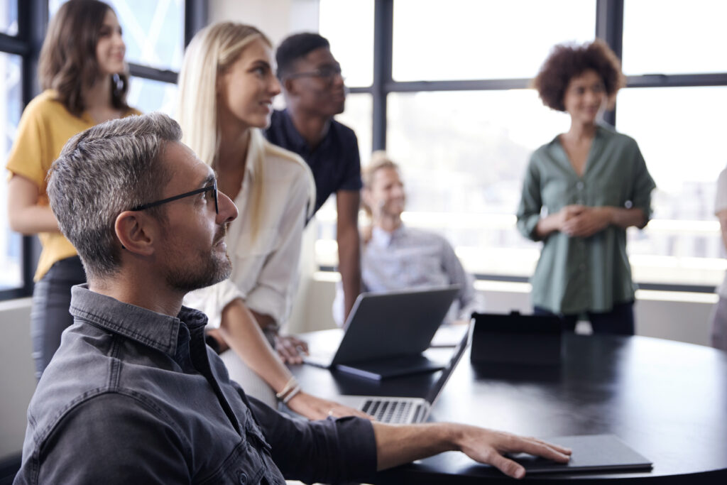 A team looking at something in the distance grouped around a conference table